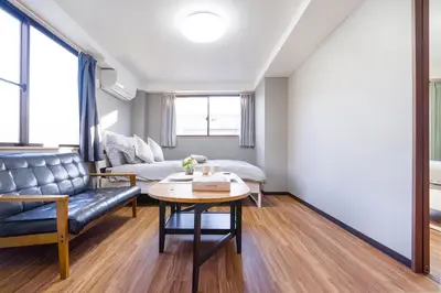 a living room with a couch and a table at Charming Guesthouse in the Heart of Okubo \u4e36Steps to Metro and Convenient Travel! SoW in Tokyo