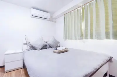 a white bedroom with a bed and a window at Charming Guesthouse in the Heart of Okubo \u4e36Steps to Metro and Convenient Travel! SoW in Tokyo