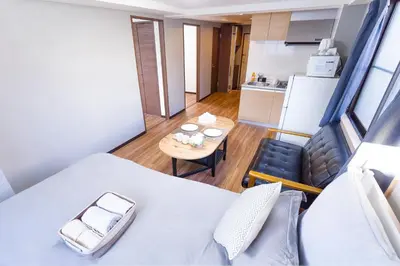 a room with a bed and a table and a kitchen at Charming Guesthouse in the Heart of Okubo \u4e36Steps to Metro and Convenient Travel! SoW in Tokyo