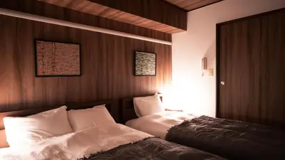 two beds in a room with wooden walls at \u30a8\u30de\u30fc\u30ec in Tokyo