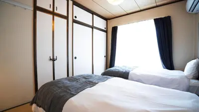 two beds in a room with a window at \u30a8\u30de\u30fc\u30ec in Tokyo