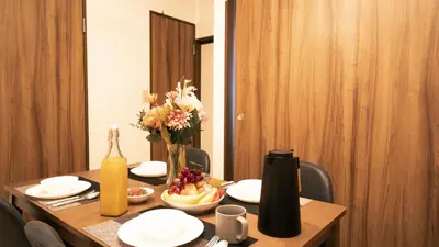 a table with a bowl of fruit and a vase of flowers at \u30a8\u30de\u30fc\u30ec in Tokyo