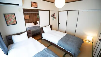 a small bedroom with two beds and a mirror at \u30a8\u30de\u30fc\u30ec in Tokyo