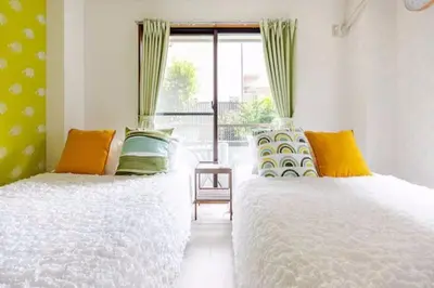 a bedroom with two beds and a window at #2 \u65b0\u5bbf\u307e\u30672\u5206 ! \u6e05\u6f54\u3067\u5b89\u5168\u306a\u90e8\u5c4b ! WiFi\u7121\u6599 ! in Tokyo