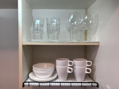 a cupboard filled with glasses and plates and bowls at #2 \u65b0\u5bbf\u307e\u30672\u5206 ! \u6e05\u6f54\u3067\u5b89\u5168\u306a\u90e8\u5c4b ! WiFi\u7121\u6599 ! in Tokyo