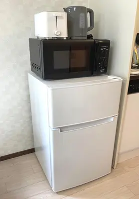 a microwave sitting on top of a refrigerator at #2 \u65b0\u5bbf\u307e\u30672\u5206 ! \u6e05\u6f54\u3067\u5b89\u5168\u306a\u90e8\u5c4b ! WiFi\u7121\u6599 ! in Tokyo