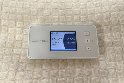 a electronic clock on a bed with the time at #2 \u65b0\u5bbf\u307e\u30672\u5206 ! \u6e05\u6f54\u3067\u5b89\u5168\u306a\u90e8\u5c4b ! WiFi\u7121\u6599 ! in Tokyo