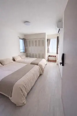 a large white bedroom with two beds in it at MUGI Stay 301 in Tokyo