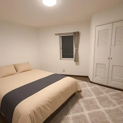 a bedroom with a large bed and a window at MUGI Stay 301 in Tokyo
