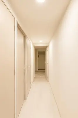 an empty corridor with white walls and a long hallway at MUGI Stay 301 in Tokyo