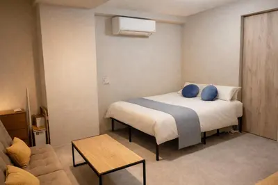a bedroom with a bed with blue pillows on it at 201 Maison de Bohème Ryogoku in Tokyo