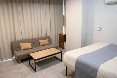a hotel room with a couch and a bed at 201 Maison de Bohème Ryogoku in Tokyo
