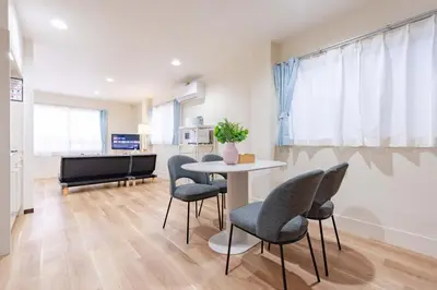 a living room with a table and chairs and a piano at \u4e80\u67095\u4e01\u76ee302 in Tokyo