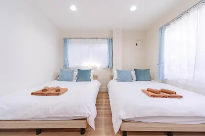 two beds with towels on them in a room at \u4e80\u67095\u4e01\u76ee302 in Tokyo