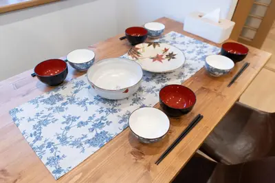 a wooden table with bowls and chopsticks on it at Skytree-House\u6771\u5411\u5cf6 in Tokyo