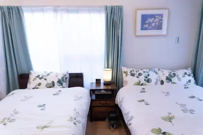 a bedroom with two beds and a window at Skytree-House\u6771\u5411\u5cf6 in Tokyo