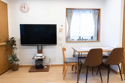a dining room with a table and a tv on a wall at Skytree-House\u6771\u5411\u5cf6 in Tokyo