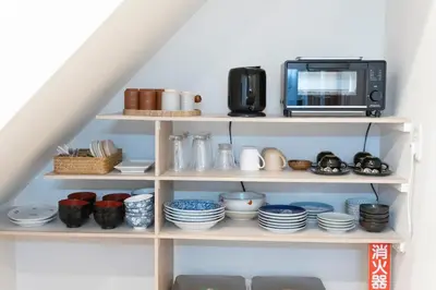 a kitchen shelf with a microwave and dishes at Skytree-House\u6771\u5411\u5cf6 in Tokyo