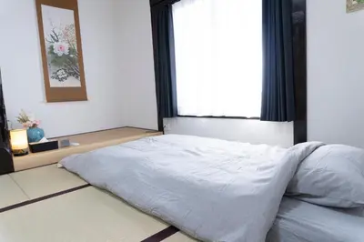 a bed in a bedroom with a large window at Skytree-House\u6771\u5411\u5cf6 in Tokyo