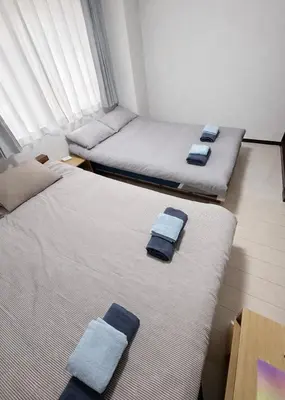 two beds in a room with blue towels on them at Shinmei Tokyo Omori in Tokyo