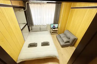 a small room with a bed and a chair at Shinmei Tokyo Omori in Tokyo
