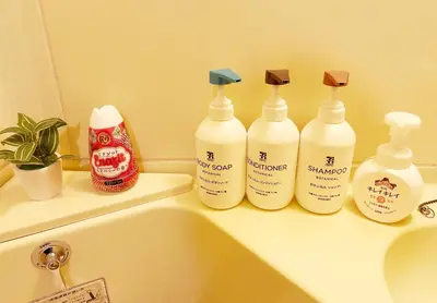a bathroom with four bottles of soap and a sink at Shinmei Tokyo Omori in Tokyo