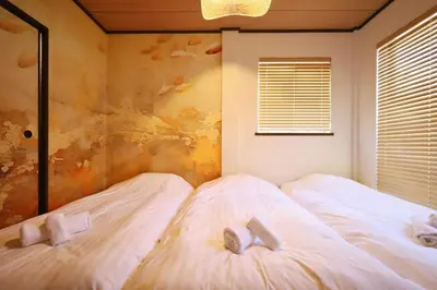two white beds in a bedroom with a window at \u30a8\u30de\u30fc\u30ec\u6771\u5c0f\u5ca9205 \u5c0f\u5ca9\u99c5\u5f92\u6b695\u5206 \u6700\u59275\u540d \u548c\u5ba4\u7573 in Tokyo