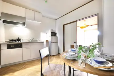 a kitchen and dining room with a wooden table at \u30a8\u30de\u30fc\u30ec\u6771\u5c0f\u5ca9205 \u5c0f\u5ca9\u99c5\u5f92\u6b695\u5206 \u6700\u59275\u540d \u548c\u5ba4\u7573 in Tokyo