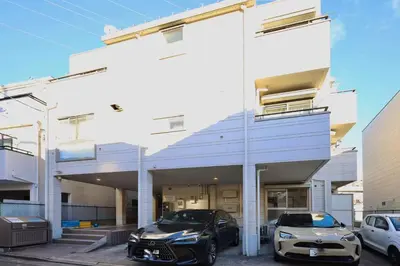 two cars parked in front of a building at \u30a8\u30de\u30fc\u30ec\u6771\u5c0f\u5ca9205 \u5c0f\u5ca9\u99c5\u5f92\u6b695\u5206 \u6700\u59275\u540d \u548c\u5ba4\u7573 in Tokyo