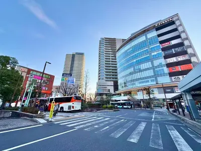 an empty street in a city with a bus at \u30a8\u30de\u30fc\u30ec\u6771\u5c0f\u5ca9205 \u5c0f\u5ca9\u99c5\u5f92\u6b695\u5206 \u6700\u59275\u540d \u548c\u5ba4\u7573 in Tokyo