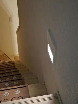 a set of stairs with a light on the wall at Sumika House in Asakusa , 5 minutes walk to asakusa ST ATION 5 bedrooms, 2 living room 2kitchen 4toilet 2bathroom 2washmachine 2fridge Newly renovated with ultra-fast WiFi in Tokyo
