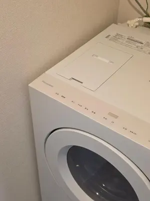 a white washing machine sitting next to a wall at Sumika House in Asakusa , 5 minutes walk to asakusa ST ATION 5 bedrooms, 2 living room 2kitchen 4toilet 2bathroom 2washmachine 2fridge Newly renovated with ultra-fast WiFi in Tokyo