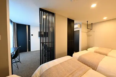 a bedroom with two beds and a desk in it at \u30a2\u30fc\u30d9\u30a4\u30f3\u65b0\u5bbf\u795e\u697d\u5742 in Tokyo
