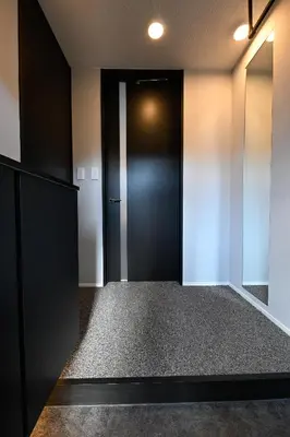 a hallway with a black door and white walls at \u30a2\u30fc\u30d9\u30a4\u30f3\u65b0\u5bbf\u795e\u697d\u5742 in Tokyo
