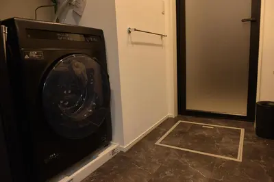 a washing machine in a room with a door at \u30a2\u30fc\u30d9\u30a4\u30f3\u65b0\u5bbf\u795e\u697d\u5742 in Tokyo