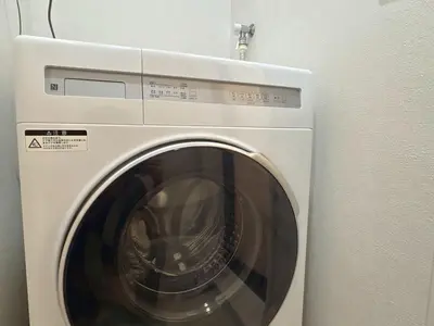 a white washing machine in a room at EASE Shinjuku in Tokyo