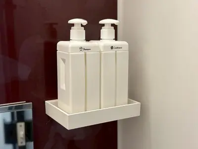two white bottles on a shelf on a wall at EASE Shinjuku in Tokyo
