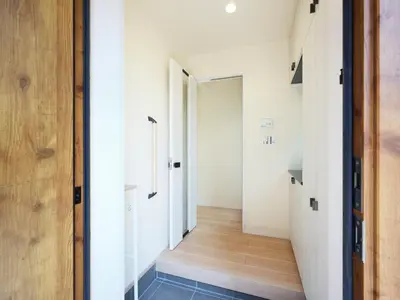 a hallway with white walls and a wooden door at \u30a2\u30f3\u30c9\u30b9\u30c6\u30a4\u5927\u5cf67\u4e01\u76ee in Tokyo