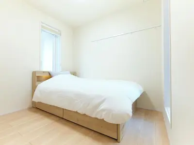 a bedroom with a bed with white sheets and a window at \u30a2\u30f3\u30c9\u30b9\u30c6\u30a4\u5927\u5cf67\u4e01\u76ee in Tokyo