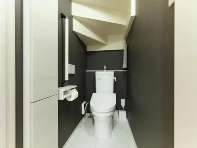 a small bathroom with a white toilet and black walls at \u30a2\u30f3\u30c9\u30b9\u30c6\u30a4\u5927\u5cf67\u4e01\u76ee in Tokyo