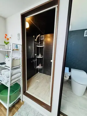 a bathroom with a shower and a toilet and a mirror at Shimokitazawa Cozy Apartment 401 in Tokyo