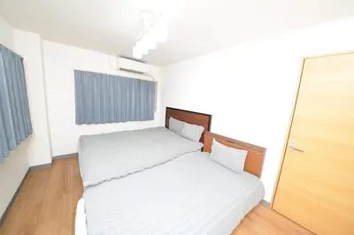 a small bedroom with two beds and a door at ACT Residence 101 2\u5ba41\u30b7\u30e3\u30ef1\u30c8\u30a4\u30ec\u65b0\u5bbf\u6587\u5316\u30bb\u30f3\u30bf\u30fc\u8fd1\u96a3 in Tokyo
