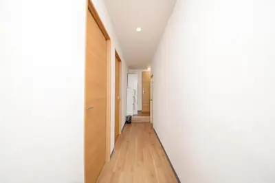 a hallway with white walls and wooden floors at ACT Residence 101 2\u5ba41\u30b7\u30e3\u30ef1\u30c8\u30a4\u30ec\u65b0\u5bbf\u6587\u5316\u30bb\u30f3\u30bf\u30fc\u8fd1\u96a3 in Tokyo