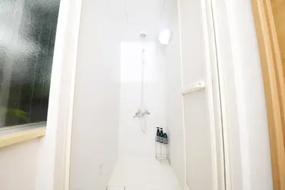 a bathroom with a shower with a white door at ACT Residence 101 2\u5ba41\u30b7\u30e3\u30ef1\u30c8\u30a4\u30ec\u65b0\u5bbf\u6587\u5316\u30bb\u30f3\u30bf\u30fc\u8fd1\u96a3 in Tokyo