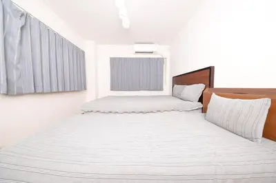 two beds in a room with white walls at ACT Residence 101 2\u5ba41\u30b7\u30e3\u30ef1\u30c8\u30a4\u30ec\u65b0\u5bbf\u6587\u5316\u30bb\u30f3\u30bf\u30fc\u8fd1\u96a3 in Tokyo