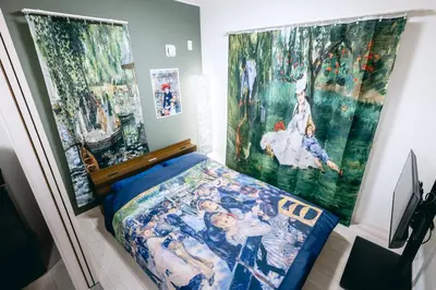 a bedroom with a bed and paintings on the wall at Pierre-Auguste Renoir Tokyo Shibuya Shinjyuku 7min Free Wifi New Open in Tokyo