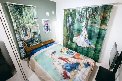 a bedroom with a bed and some paintings on the wall at Pierre-Auguste Renoir Tokyo Shibuya Shinjyuku 7min Free Wifi New Open in Tokyo