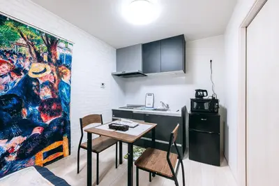 a kitchen with a table and a sink and a painting at Pierre-Auguste Renoir Tokyo Shibuya Shinjyuku 7min Free Wifi New Open in Tokyo