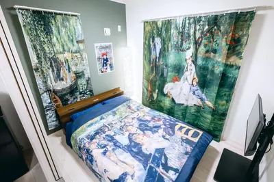 a bedroom with a bed and paintings on the wall at Pierre-Auguste Renoir Tokyo Shibuya Shinjyuku 7min Free Wifi New Open in Tokyo