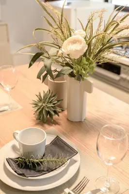 a table with a plate and a cup and a vase with flowers at Ueno Asakusa Area Spacious 90sqm Home Comfortable Tokyo Stay Up to 8 Guests in Tokyo